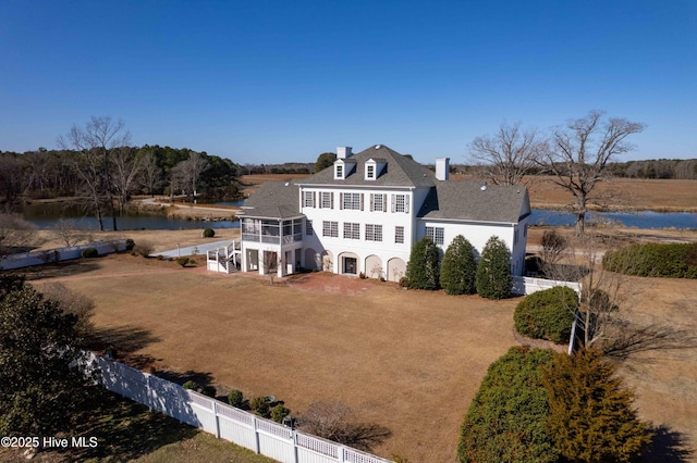 back of house featuring a sunroom and a water view