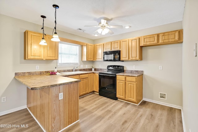 kitchen with visible vents, black appliances, a peninsula, light wood finished floors, and baseboards