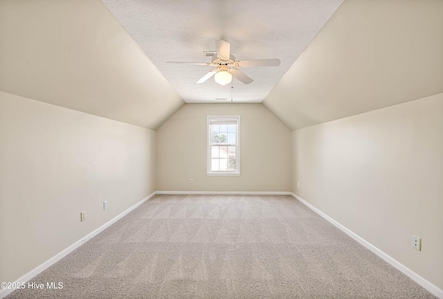 additional living space with a ceiling fan, baseboards, vaulted ceiling, a textured ceiling, and carpet flooring