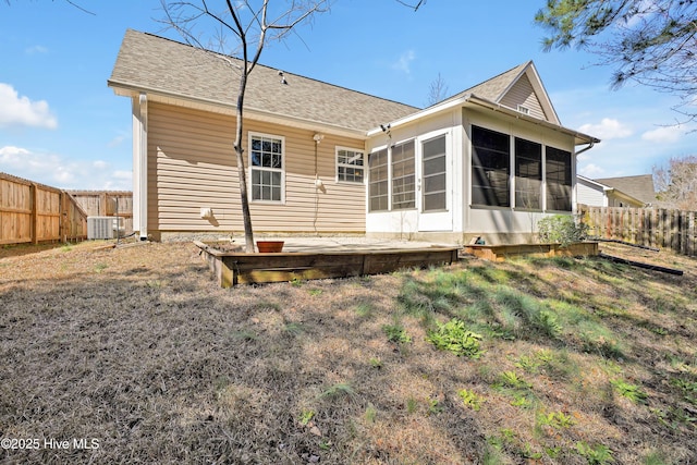 back of property featuring central air condition unit, a fenced backyard, a sunroom, and roof with shingles