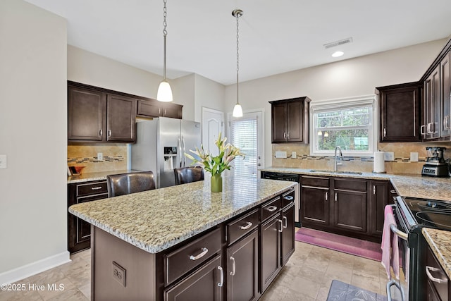 2306 Cottagefield Ln, Leland, NC 28451 - kitchen featuring sink, stainless steel refrigerator with ice dispenser, a center island, range with electric cooktop, and hanging light fixtures