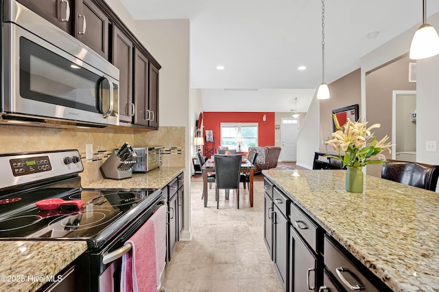 2306 Cottagefield Ln, Leland, NC 28451 - kitchen featuring stainless steel appliances, dark brown cabinetry, decorative light fixtures, light stone countertops, and tasteful backsplash