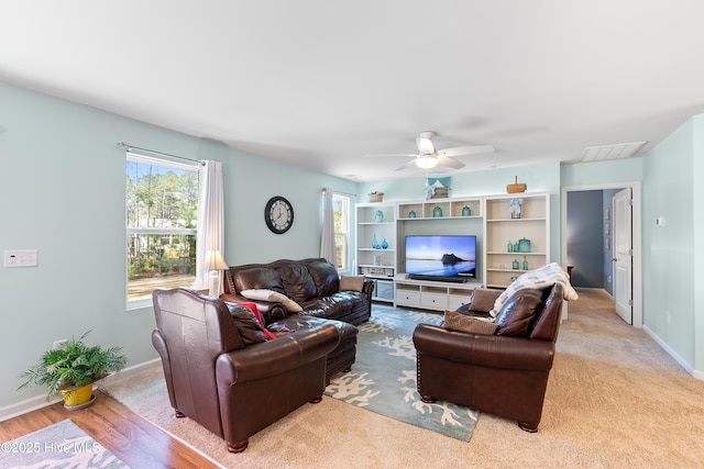 living area with ceiling fan, visible vents, and baseboards