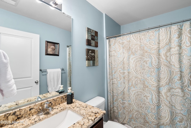 bathroom with toilet, visible vents, and vanity