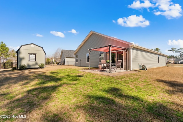 rear view of property featuring a lawn, an outbuilding, fence, a patio area, and a shed