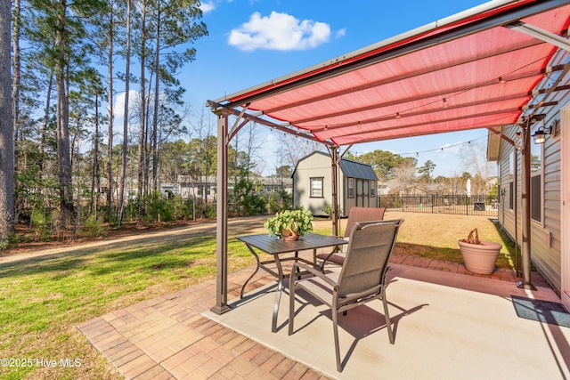 view of patio featuring an outbuilding, a storage shed, outdoor dining space, and fence