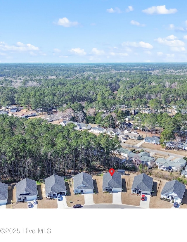 birds eye view of property featuring a residential view and a wooded view