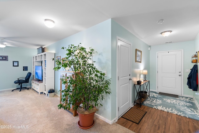 foyer featuring baseboards, a ceiling fan, and wood finished floors