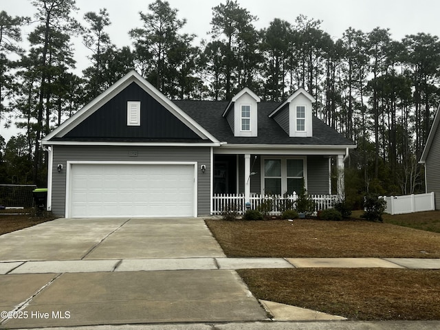 view of front of house with a porch, concrete driveway, roof with shingles, and a garage