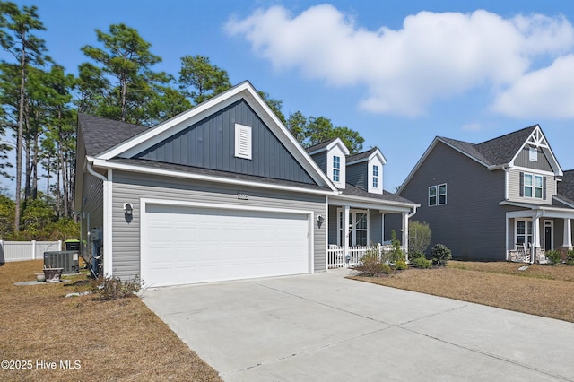 view of front of property with concrete driveway, covered porch, board and batten siding, fence, and a garage