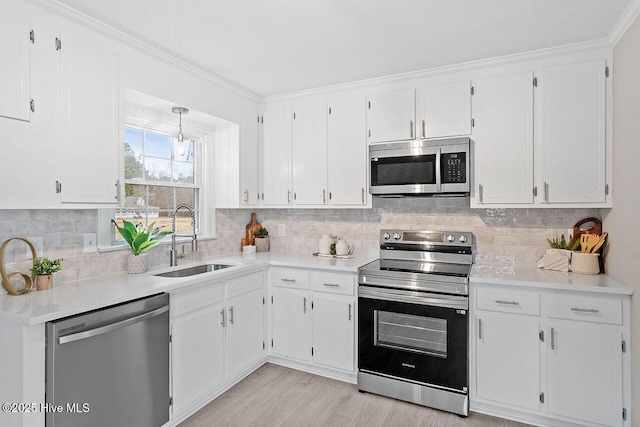 kitchen with sink, decorative backsplash, white cabinets, and appliances with stainless steel finishes