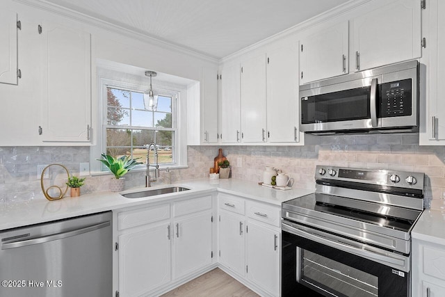 kitchen featuring sink, white cabinetry, tasteful backsplash, light hardwood / wood-style flooring, and appliances with stainless steel finishes