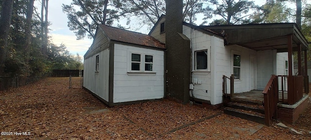 exterior space with roof with shingles and fence