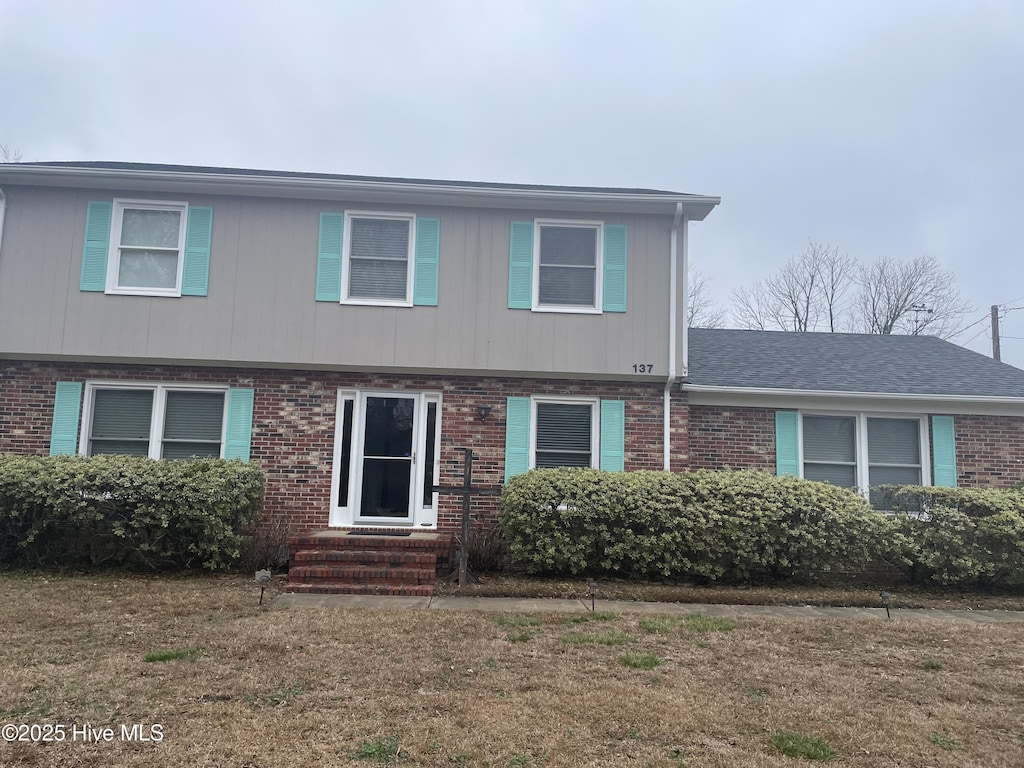 view of front of home with entry steps and brick siding