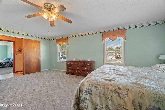 bedroom with light colored carpet, a textured ceiling, and ceiling fan