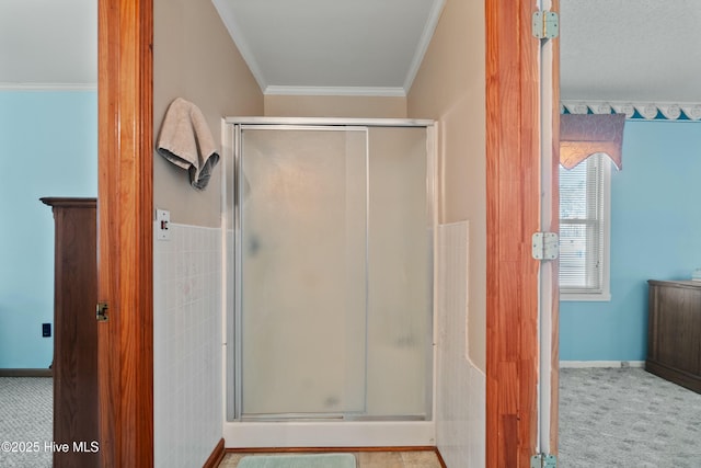 bathroom with ornamental molding and a shower with door