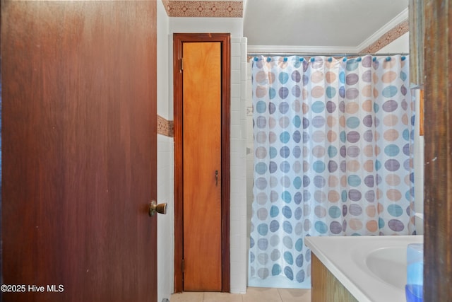 bathroom featuring tile patterned flooring, ornamental molding, and tile walls