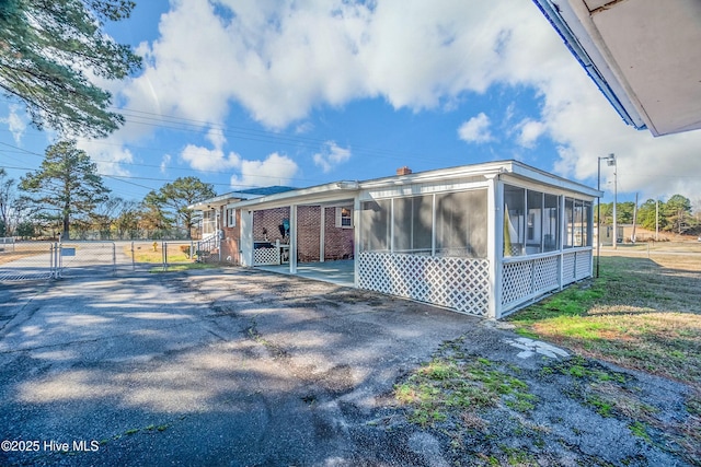 view of property exterior featuring a patio and a sunroom