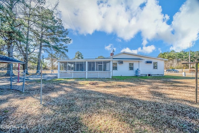 view of front of house with a front yard and a sunroom