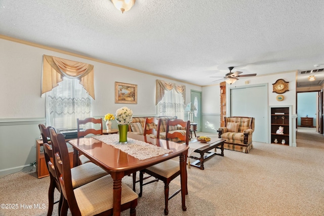 dining area featuring ornamental molding, plenty of natural light, and light carpet