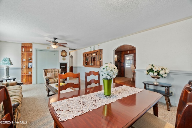 dining area featuring ceiling fan, carpet flooring, and a textured ceiling