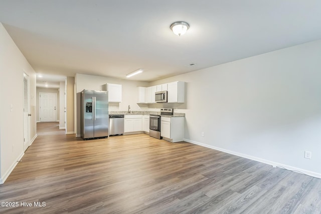 kitchen featuring white cabinetry, appliances with stainless steel finishes, sink, and light wood-type flooring