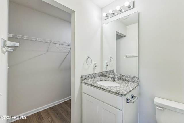 bathroom with vanity, hardwood / wood-style flooring, and toilet