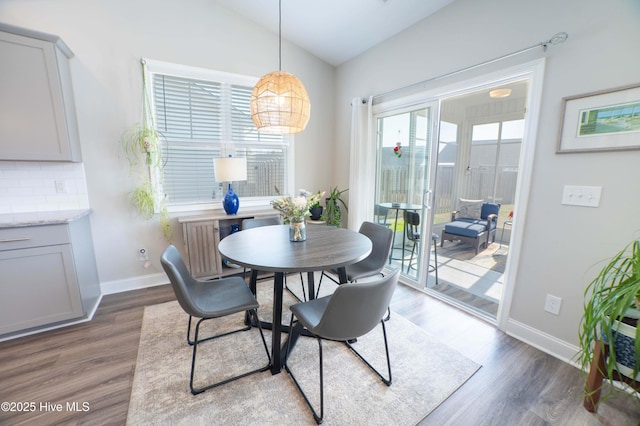 dining area featuring lofted ceiling and dark hardwood / wood-style flooring