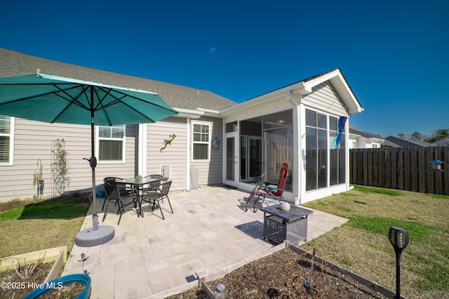 exterior space with a patio, a sunroom, and a lawn