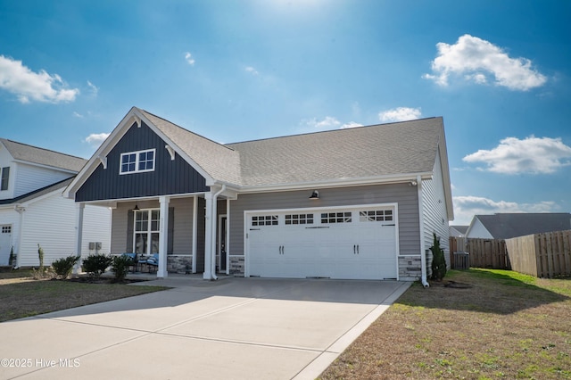 view of front of home featuring a porch, a garage, and a front lawn