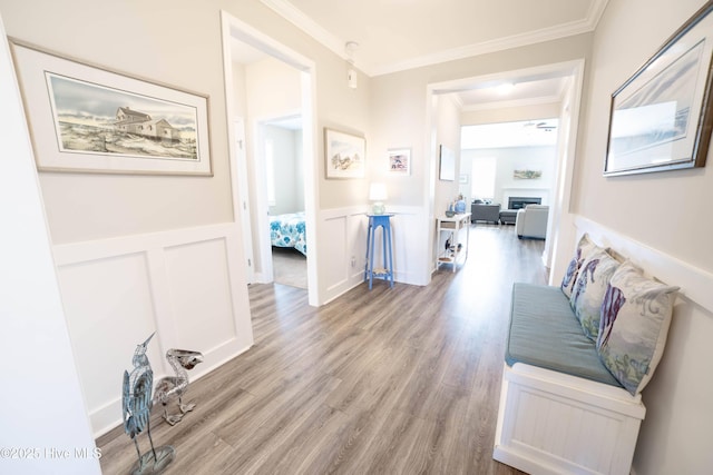 hall with ornamental molding and light wood-type flooring