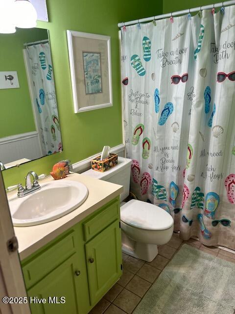 full bath featuring a shower with shower curtain, vanity, toilet, and tile patterned floors