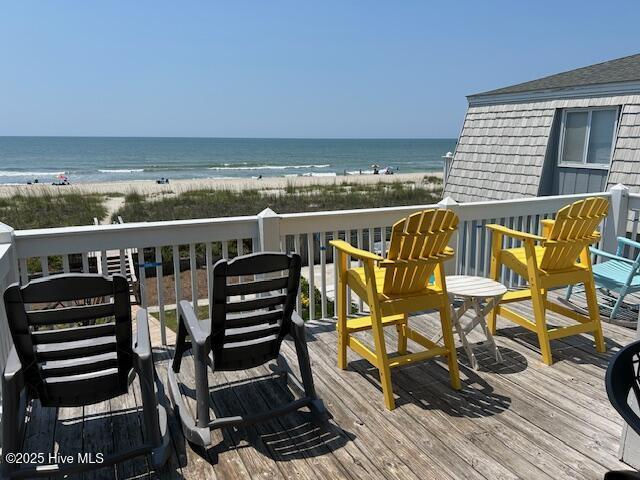 balcony with a deck with water view and a view of the beach