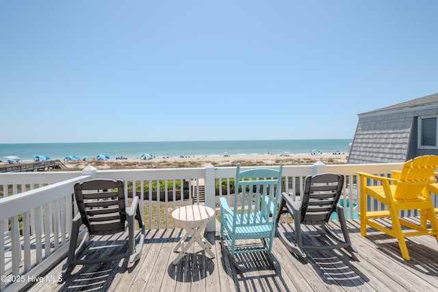 wooden terrace featuring a view of the beach and a water view