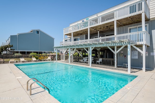 community pool with fence and a patio area