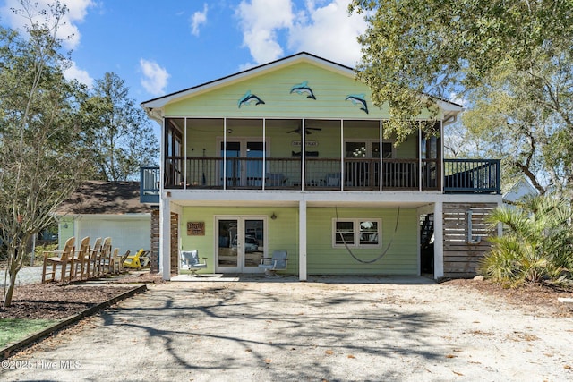 view of front facade featuring french doors, ceiling fan, driveway, and stairs