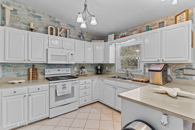 169 NW 7th St, Oak Island, NC 28465 - kitchen with white appliances, a sink, vaulted ceiling, white cabinetry, and tasteful backsplash