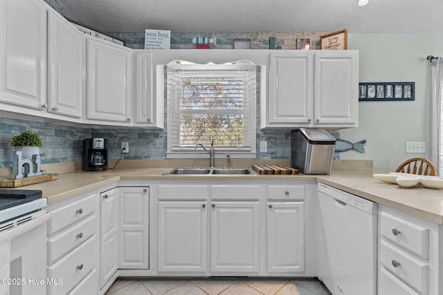 169 NW 7th St, Oak Island, NC 28465 - kitchen with white appliances, a sink, white cabinets, and tasteful backsplash