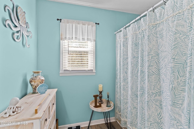 169 NW 7th St, Oak Island, NC 28465 - bathroom with a shower with shower curtain and wood finished floors