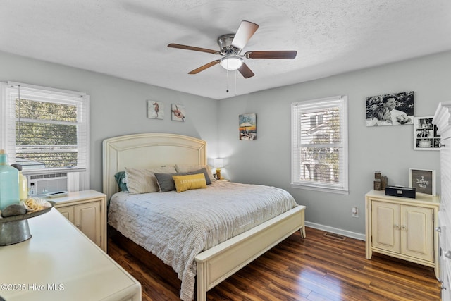 169 NW 7th St, Oak Island, NC 28465 - bedroom with dark wood-type flooring, baseboards, a ceiling fan, a textured ceiling, and cooling unit