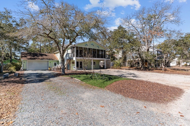 view of front of home with driveway, a sunroom, and an attached garage