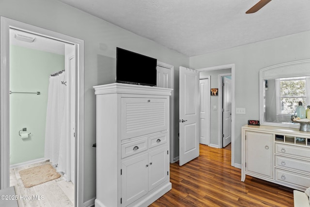169 NW 7th St, Oak Island, NC 28465 - bedroom with dark wood finished floors, baseboards, a ceiling fan, and a textured ceiling
