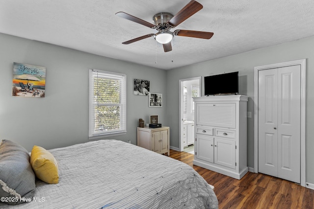 169 NW 7th St, Oak Island, NC 28465 - bedroom with dark wood-style flooring, a textured ceiling, a ceiling fan, ensuite bath, and baseboards