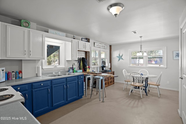 169 NW 7th St, Oak Island, NC 28465 - kitchen with blue cabinetry, a sink, light countertops, and healthy amount of natural light