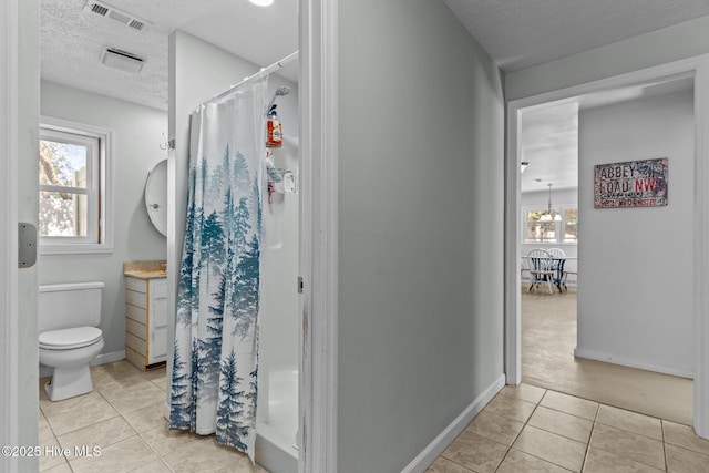 169 NW 7th St, Oak Island, NC 28465 - bathroom featuring a textured ceiling, tile patterned floors, plenty of natural light, and a shower stall