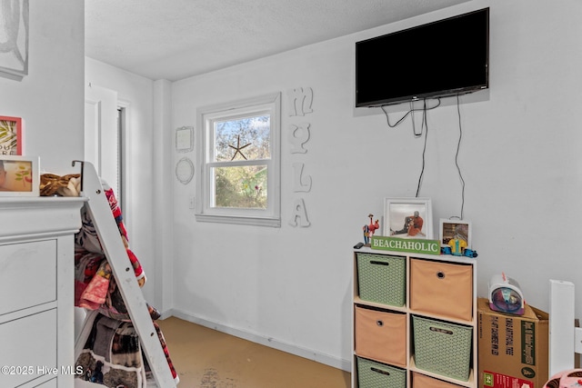 169 NW 7th St, Oak Island, NC 28465 - rec room with baseboards, concrete flooring, and a textured ceiling