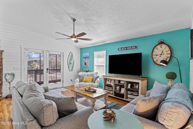 169 NW 7th St, Oak Island, NC 28465 - living room with french doors, lofted ceiling, wood finished floors, ceiling fan, and a textured ceiling