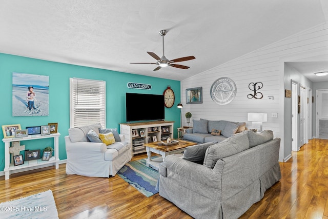 169 NW 7th St, Oak Island, NC 28465 - living room with ceiling fan, wood finished floors, vaulted ceiling, baseboards, and wood walls
