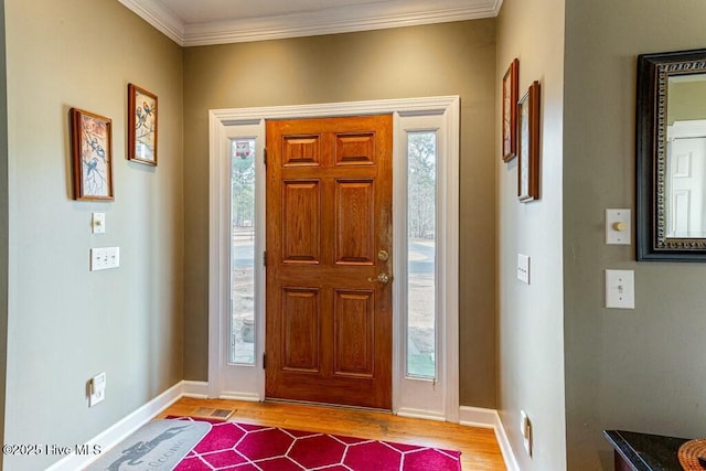 entryway with ornamental molding, a wealth of natural light, and wood finished floors