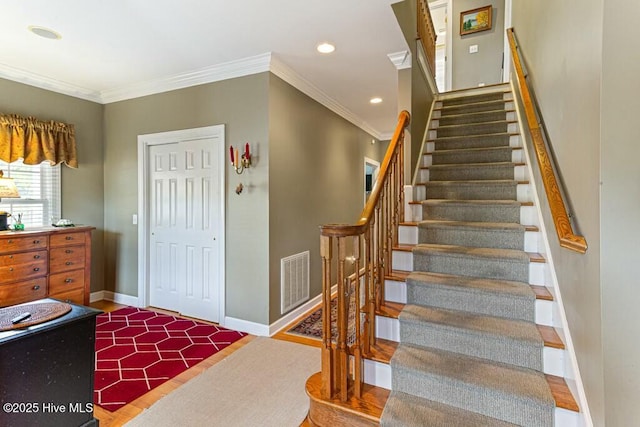 staircase with baseboards, visible vents, crown molding, and recessed lighting